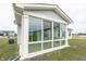 Enclosed sunroom with large windows offers views of the lush backyard at 1863 River Birch Dr, Greenfield, IN 46140