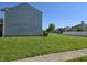 View of a home's backyard with lush green grass, landscaping, and a partial fence at 2248 Salem Park Dr, Indianapolis, IN 46239
