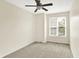 Bright bedroom features neutral carpet, ceiling fan, and window bringing in natural light at 2306 Brightwell Pl, Indianapolis, IN 46260
