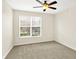 Bright bedroom features neutral carpet, ceiling fan, and window bringing in natural light at 2306 Brightwell Pl, Indianapolis, IN 46260