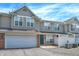 Inviting townhome features a one-car garage, green door, and charming white picket fence, creating a welcoming curb appeal at 2306 Brightwell Pl, Indianapolis, IN 46260