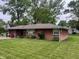 Charming brick ranch-style home with mature trees and a well-maintained front lawn at 2330 Ridgewood Dr, Anderson, IN 46012