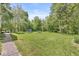 Large backyard featuring a lush lawn, mature trees, a trampoline, and outdoor seating, perfect for recreation and relaxation at 2346 N State Road 39, Danville, IN 46122