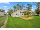 Backyard view of a light siding house with a wood pergola and a table with chairs on the wood deck at 2414 N Blaine St, Muncie, IN 47303