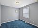 Cozy bedroom with blue carpet and neutral gray paint, providing a serene and inviting atmosphere at 2414 N Blaine St, Muncie, IN 47303