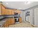 Kitchen featuring stainless steel appliances, wood cabinets, and a laundry closet at 2414 N Blaine St, Muncie, IN 47303