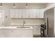 Bright kitchen with white cabinets, stainless steel appliances, a stylish island, and modern pendant lights at 2417 N Rural N Ave, Indianapolis, IN 46218