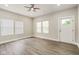 Well-lit living room with wood-look floors, modern ceiling fan, and a bright white door at 2417 N Rural N Ave, Indianapolis, IN 46218