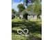 A gray house sits in a grassy backyard with scattered trees and a small shed in the distance at 2421 N Arsenal Ave, Indianapolis, IN 46218