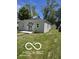 Charming single-story home with a well-maintained lawn, gray exterior, and a black front door at 2421 N Arsenal Ave, Indianapolis, IN 46218