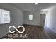Bright living room features hardwood floors, white walls, and a large window with natural light at 2421 N Arsenal Ave, Indianapolis, IN 46218
