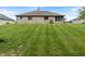 A spacious backyard with a well-manicured lawn and a brick home at 2422 Oak Dr, Clayton, IN 46118