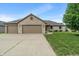 Charming brick home with a three-car garage and a well-manicured lawn on a sunny day at 2422 Oak Dr, Clayton, IN 46118