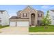 Inviting two-story brick home features a three-car garage and manicured lawn at 2502 Creekland Dr, Columbus, IN 47201