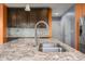 Kitchen island featuring granite countertops, stainless steel sink, faucet, and dark cabinets at 2502 Creekland Dr, Columbus, IN 47201
