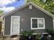 Home exterior with gray siding, white trim, and a cozy entrance, surrounded by colorful flower bed at 3041 S Rybolt Ave, Indianapolis, IN 46241