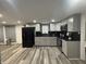 Modern kitchen with gray cabinets, stainless steel appliances, black countertop, and wood flooring at 3041 S Rybolt Ave, Indianapolis, IN 46241