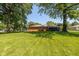 View of the backyard with a well-maintained lawn and mature trees, creating a peaceful, private outdoor space at 3105 E Banta Rd, Indianapolis, IN 46227