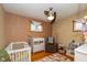 Charming Bedroom with hardwood floors, a crib, and a cozy rocking chair, ready for a new Gathering at 3105 E Banta Rd, Indianapolis, IN 46227