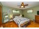 Cozy bedroom features hardwood floors, a ceiling fan, and plenty of natural light at 3105 E Banta Rd, Indianapolis, IN 46227