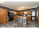 A well-lit kitchen is equipped with wooden cabinets, black appliances, and a central island at 3105 E Banta Rd, Indianapolis, IN 46227