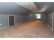 Spacious attic features gray walls and carpeting, with recessed lights and natural light from a window at 3602 N Colorado Ave, Indianapolis, IN 46218