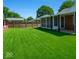 Beautiful backyard features a perfectly manicured lawn, privacy fence, and screened-in porch at 3602 N Colorado Ave, Indianapolis, IN 46218