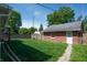 Backyard with a well-maintained lawn, wooden privacy fence, and detached garage at 3602 N Colorado Ave, Indianapolis, IN 46218