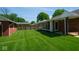 Well-maintained backyard with lush green lawn, privacy fence, and charming exterior home design at 3602 N Colorado Ave, Indianapolis, IN 46218