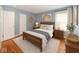 Comfortable bedroom with a wooden bed frame, hardwood floors, and bright natural light at 3602 N Colorado Ave, Indianapolis, IN 46218