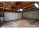Spacious garage with exposed wood beams, concrete block walls, and a gray garage door at 3602 N Colorado Ave, Indianapolis, IN 46218