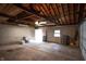 Spacious garage with exposed wood beams, concrete block walls, and a concrete floor at 3602 N Colorado Ave, Indianapolis, IN 46218