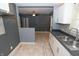 Updated kitchen boasts white cabinets, stainless steel sink, and modern tile flooring at 3602 N Colorado Ave, Indianapolis, IN 46218