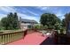 Red painted wood deck with table and chairs overlooks spacious backyard and trees at 404 Joseph Way, Carmel, IN 46032