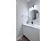 Renovated half bathroom features a modern round mirror, white cabinets, and faucet at 404 Joseph Way, Carmel, IN 46032
