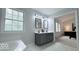Bright bathroom featuring a double vanity, soaking tub, and view to the main bedroom suite at 404 Joseph Way, Carmel, IN 46032