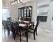 Dining area with modern light fixture and a display cabinet, adjacent to the kitchen with white cabinets at 404 Joseph Way, Carmel, IN 46032