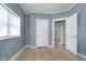 Light-filled bedroom featuring wood flooring, a window, and an open door frame at 4325 Norwaldo Ave, Indianapolis, IN 46205