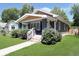 Attractive bungalow featuring a covered porch, well-maintained lawn, and landscaped yard at 4325 Norwaldo Ave, Indianapolis, IN 46205
