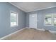Living room with light-colored wood flooring, light blue walls, and multiple windows for ample natural light at 4325 Norwaldo Ave, Indianapolis, IN 46205