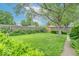 Beautiful back yard with lush green lawn, mature trees, and privacy hedges, creating a serene outdoor space at 445 N 13Th Ave, Beech Grove, IN 46107