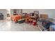 Basement living area featuring tiled floors, comfortable seating, and a bedroom area with a warm orange blanket at 445 N 13Th Ave, Beech Grove, IN 46107