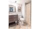 Well-lit bathroom with a modern vanity, patterned shower curtain, and tiled floor at 445 N 13Th Ave, Beech Grove, IN 46107