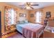 Bright bedroom with patterned curtains, colorful bedding, and a ceiling fan at 445 N 13Th Ave, Beech Grove, IN 46107