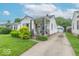 Exterior view of a charming home with a well-kept lawn, tidy landscaping, and a detached garage at 445 N 13Th Ave, Beech Grove, IN 46107