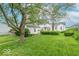 Well-maintained front yard with green lawn, mature trees, and a charming white house with tidy landscaping at 445 N 13Th Ave, Beech Grove, IN 46107