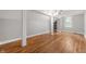 Open bedroom area with hardwood floors, light-colored walls, columns, and a window at 5312 E Southern Ave, Indianapolis, IN 46203