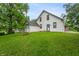Charming white two-story house featuring black trim, lush greenery, and a well-maintained lawn at 5312 E Southern Ave, Indianapolis, IN 46203