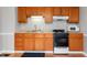 Bright kitchen with light-colored walls and wood cabinets with black and white appliances at 5312 E Southern Ave, Indianapolis, IN 46203
