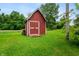 The property features a charming red shed surrounded by lush greenery and trees at 5312 E Southern Ave, Indianapolis, IN 46203